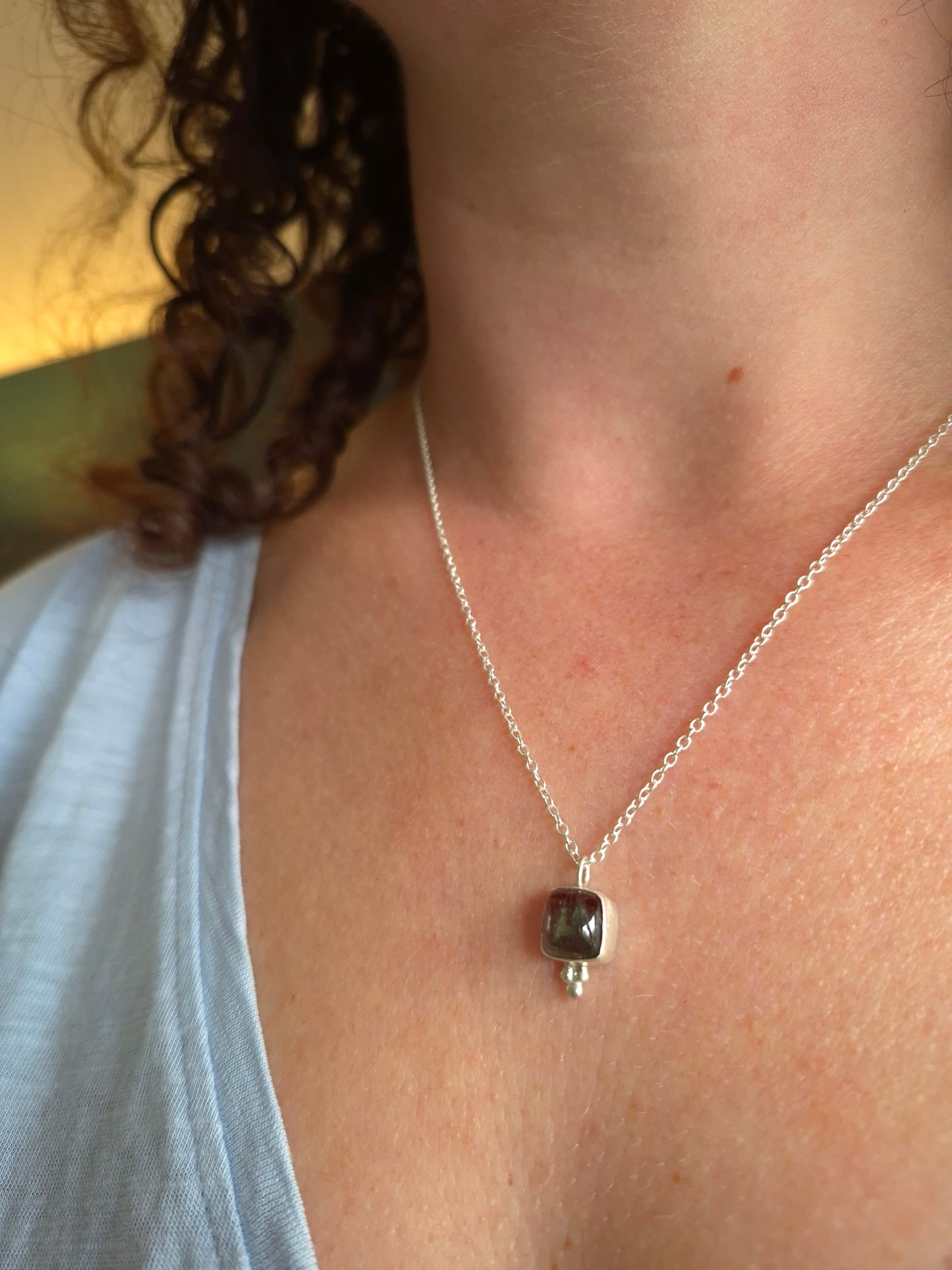 Necklace with a pendant on a person's neck