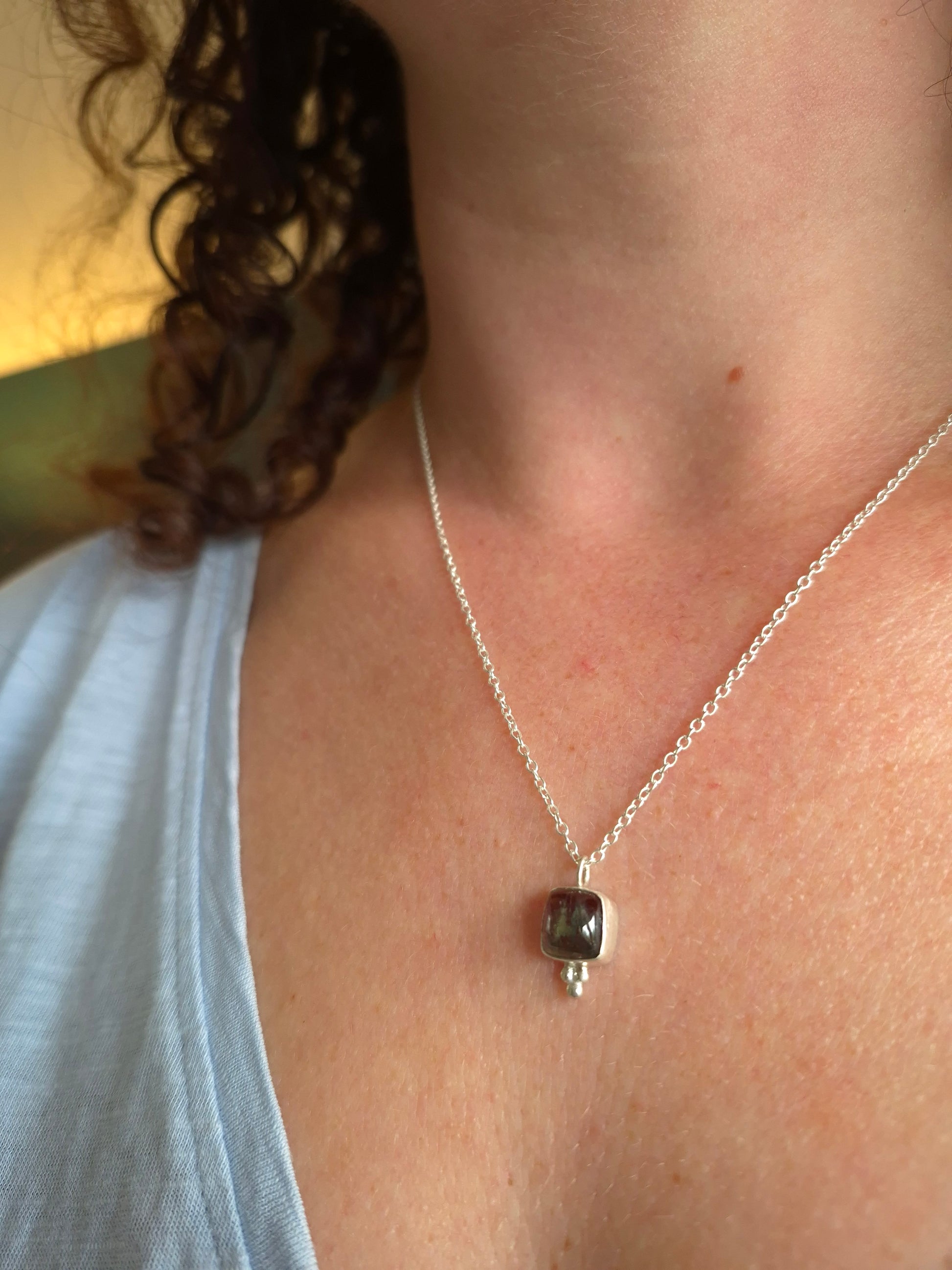 Necklace with a pendant on a person's neck