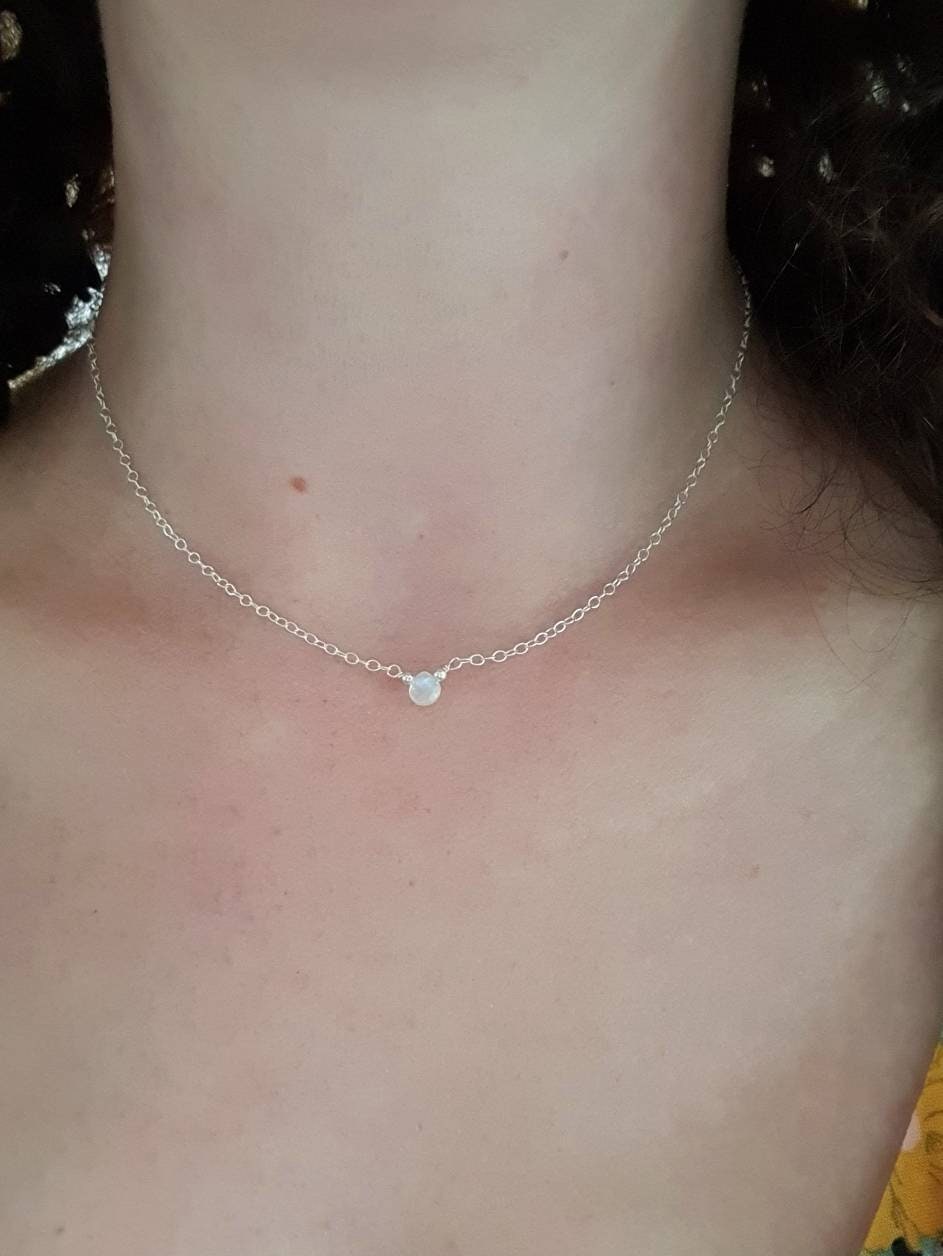 Necklace with a small pendant worn by a person