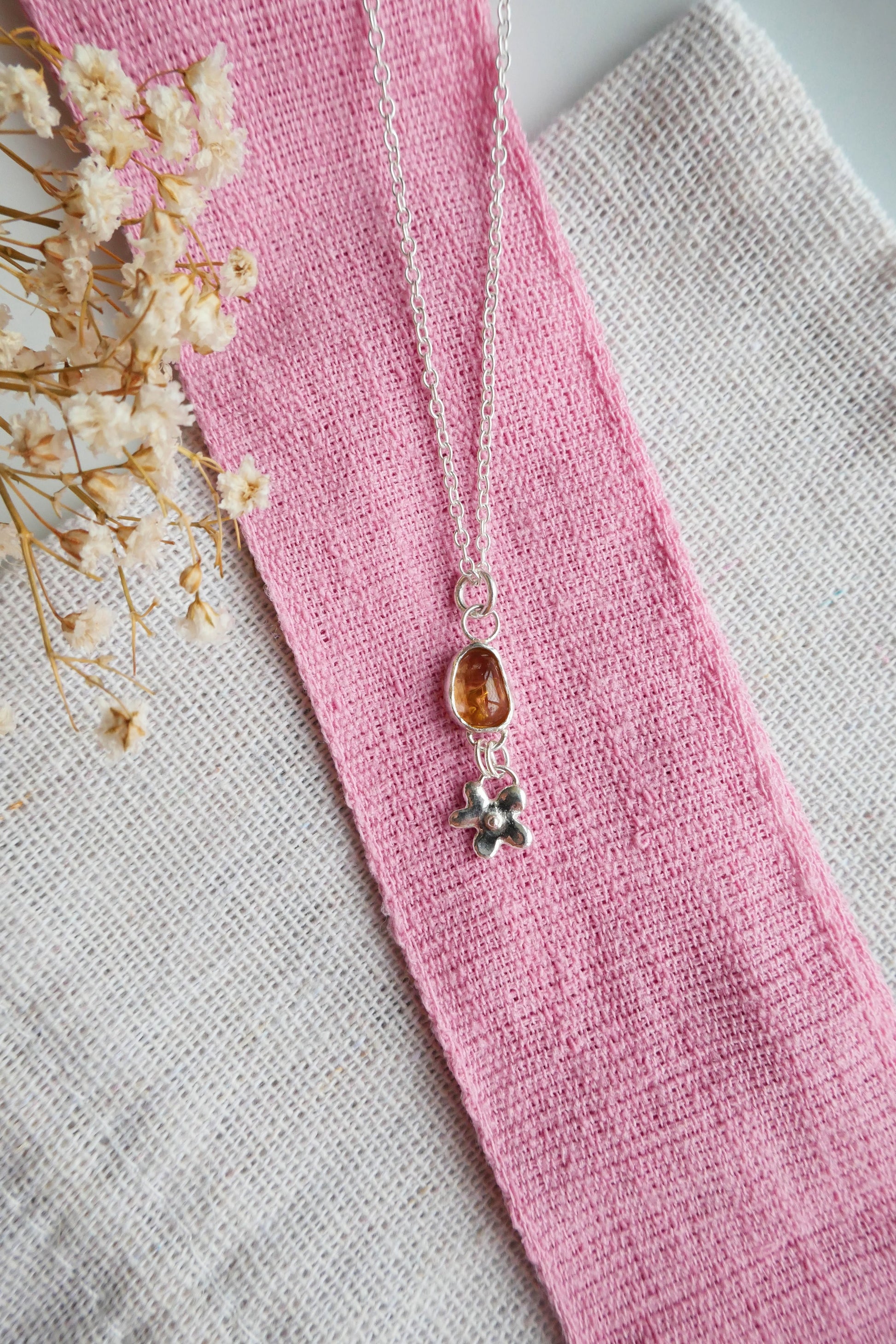 Necklace with a pendant on a pink fabric background