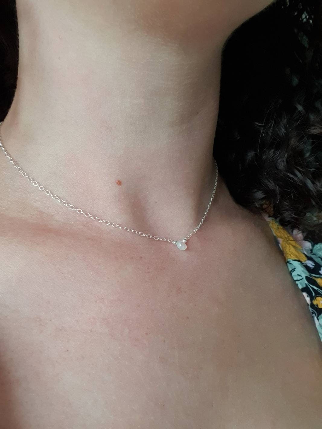 Close-up of a necklace on a person's neck with a blurred background